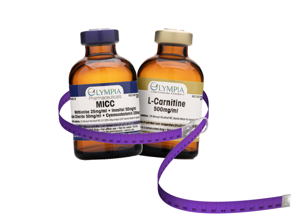Two amber-colored vials labeled "MICC" and "L-Carnitine 500mg/ml" from Olympia Compounding Pharmacy, wrapped with a coiled purple measuring tape.