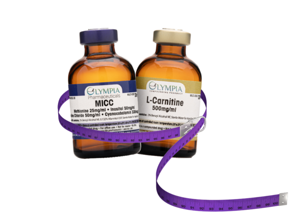 Two amber-colored vials labeled "MICC" and "L-Carnitine 500mg/ml" from Olympia Compounding Pharmacy, wrapped with a coiled purple measuring tape.